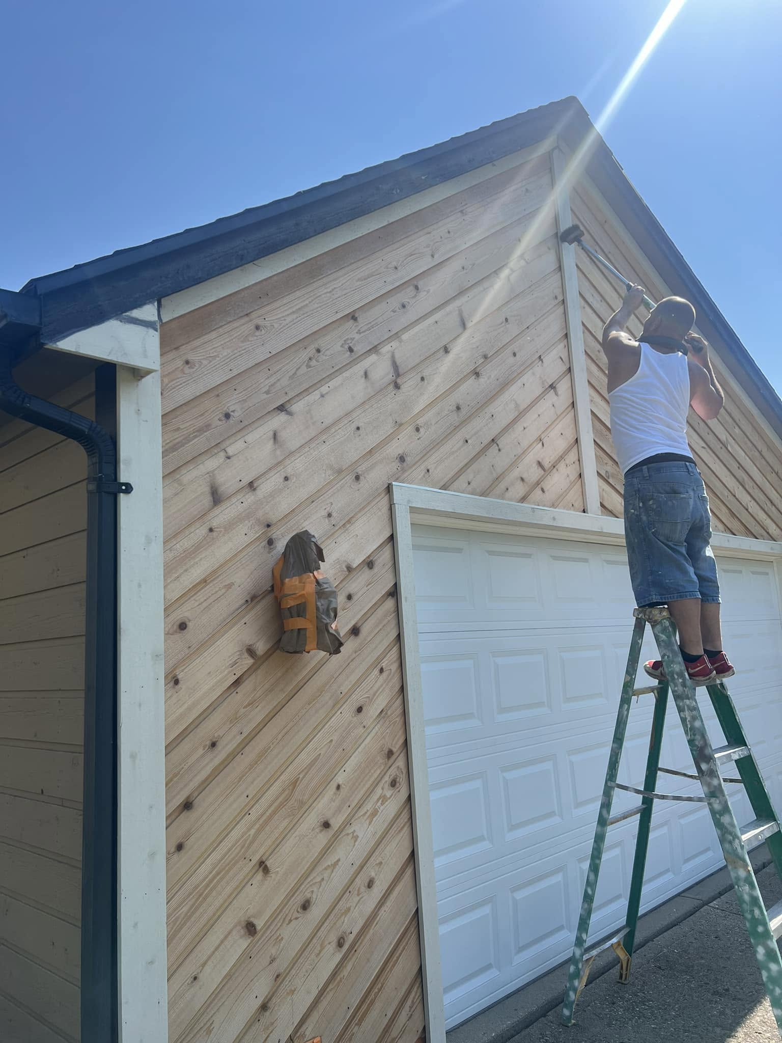 Painter carefully working on the side of a home exterior